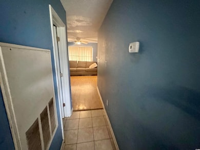 Corridor featuring light tile patterned floors and baseboards