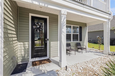 View of front facade featuring a balcony, concrete driveway, an attached garage, and a front yard