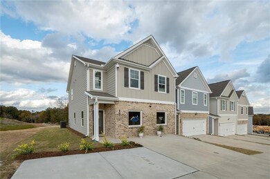 Craftsman inspired home featuring concrete driveway, board and batten siding, brick siding, and a garage
