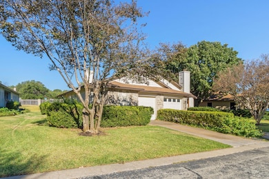 Obstructed view of property with brick siding, a chimney, a garage, and concrete driveway