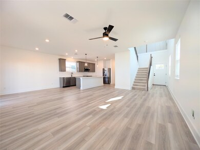 Unfurnished living room featuring stairway, light wood-style floors, ceiling fan, and recessed lighting