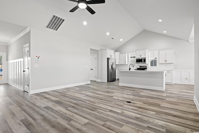 Unfurnished living room featuring ceiling fan, lig