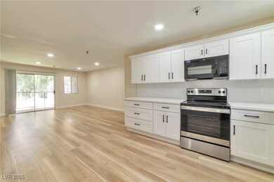 Kitchen with electric range, black microwave, ligh