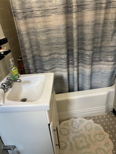 Bathroom with shower / bath combo with shower curtain and vanity