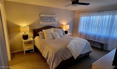 Carpeted bedroom featuring baseboards, ceiling fan