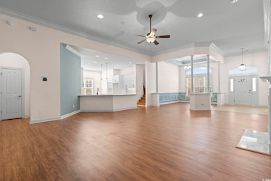 Unfurnished living room featuring LVF, ornamental molding, plenty of natural light, recessed lighting, and a ceiling fan