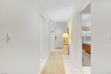 Corridor with a textured ceiling, baseboards, and 