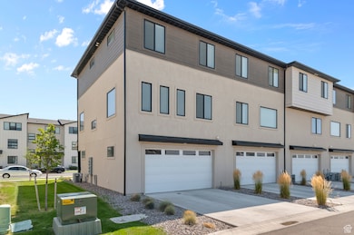 View of building exterior featuring concrete driveway and an attached garage