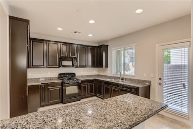 Kitchen featuring black appliances, plenty of natu