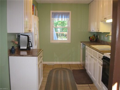 White cabinets and ceramic tile in step-saving, galley kitchen.