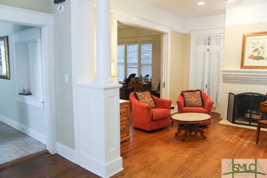 Living room with fireplace and tall windows.