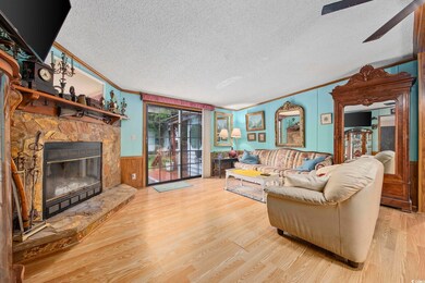 Living room with a fireplace, crown molding, a tex