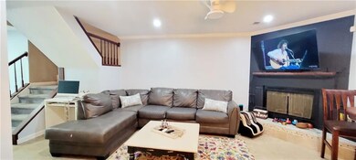 Living room with ornamental molding and ceiling fa