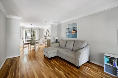 Living room featuring crown molding and light hard
