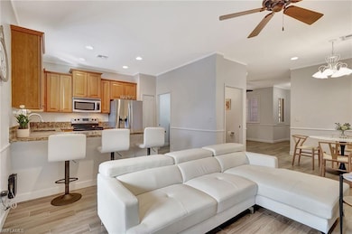 Living room with ceiling fan with notable chandeli
