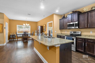 Kitchen featuring decorative light fixtures, stainless steel appliances, a chandelier, sink, and a center island with sink