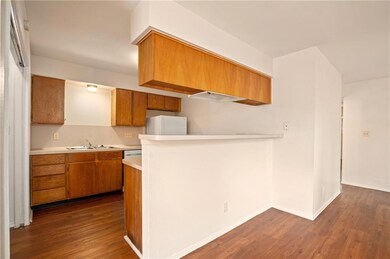 Kitchen with light countertops, dark wood-style f