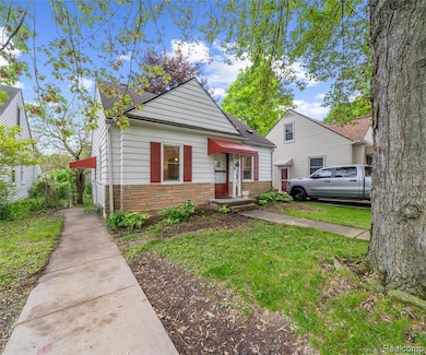Bungalow-style home with stone siding, roof with shingles, and a front yard