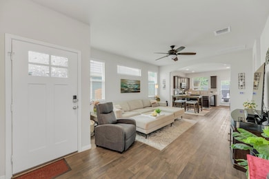 Living area with wood finished floors, ceiling fa