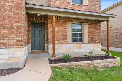 View of exterior entry with brick siding, a porch