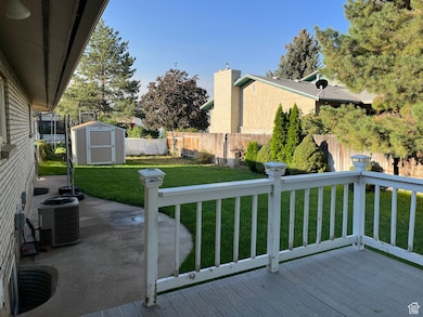 Deck featuring a storage shed, a fenced backyard, and a patio