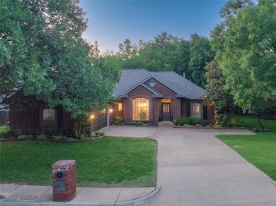 View of front of house with driveway, a front lawn, an attached garage, and brick siding