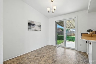 Unfurnished dining area featuring a chandelier and vaulted ceiling