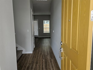 Hallway featuring baseboards, dark wood finished 