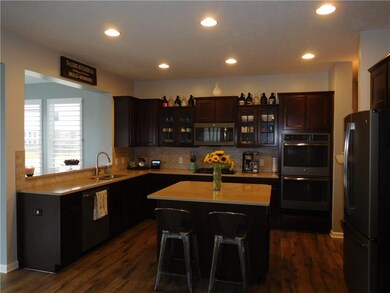 Spacious kitchen features the gourmet update including granite counters, tiled back splash, staggered height cabinets with crown molding and slate appliances. 