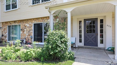 Doorway to property featuring stone siding and covered porch