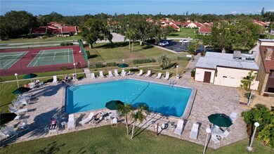 A view of the large pool and deck area with tennis just beyond
