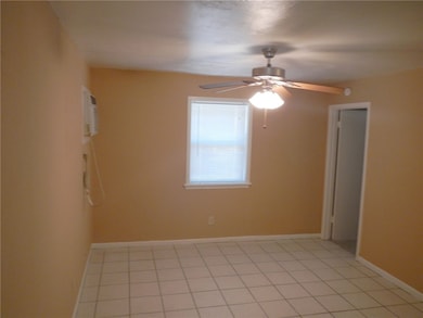 Spare room with ceiling fan and baseboards