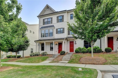 Townhome / multi-family property with brick siding, a front yard, and a standing seam roof