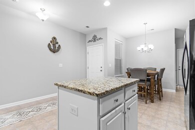 Kitchen featuring black fridge, hanging light fixt