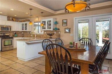 French doors lead out to pool, outdoor kitchen and