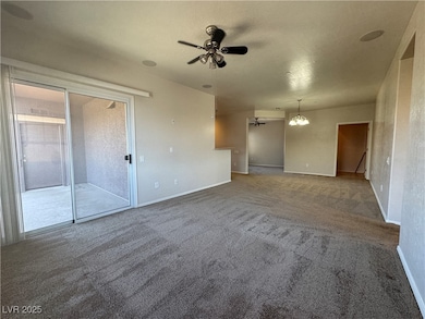 Carpeted empty room with ceiling fan and a chandel