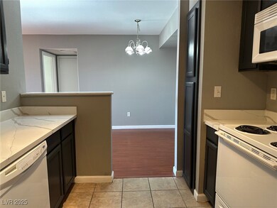 Kitchen featuring white appliances, light stone co