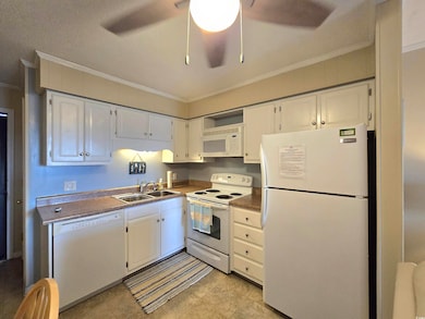 Kitchen featuring a sink, ceiling fan, white appli