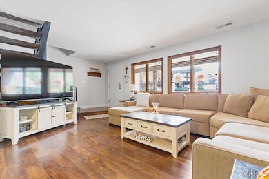 Living area with dark wood finished floors and baseboards
