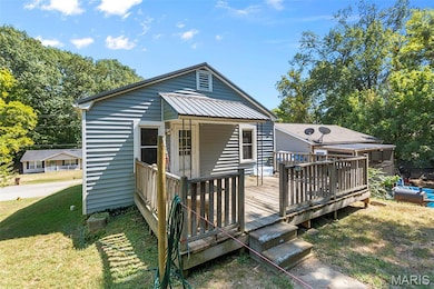 View of front of house featuring a wooden deck and a front lawn