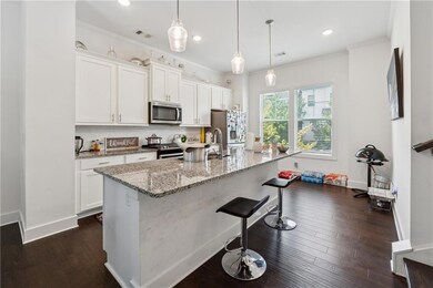 Kitchen featuring appliances with stainless steel finishes, tasteful backsplash, white cabinetry, a breakfast bar area, and recessed lighting