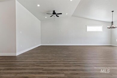 Unfurnished room featuring vaulted ceiling, ceiling fan, recessed lighting, a chandelier, and dark wood-style flooring