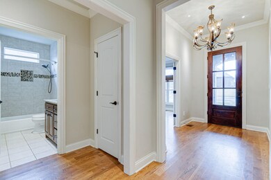 Entry hallway into full hall bathroom and coat closet.  All open doorways and windows in home are wood framed!