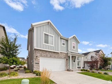 Craftsman-style house with board and batten siding, stone siding, a garage, and concrete driveway
