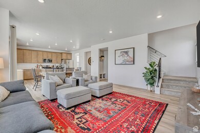 Living area featuring recessed lighting, stairway, and light wood-style floors