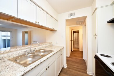  A modern kitchen with white cabinetry, granite-lo