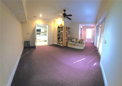 Unfurnished living room with ceiling fan and crown