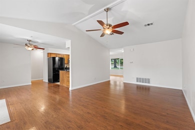 Unfurnished living room with a ceiling fan, vault
