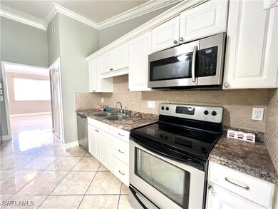 Kitchen featuring white cabinetry, ornamental mold