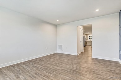Unfurnished room featuring wood finished floors, b